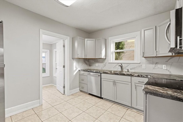 kitchen featuring backsplash, sink, light tile patterned flooring, and stainless steel appliances