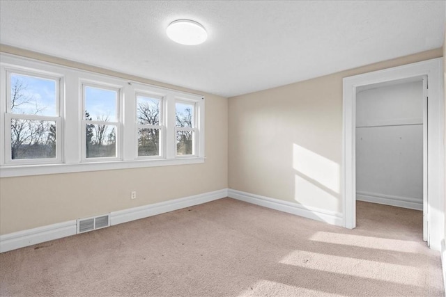 unfurnished bedroom featuring a closet, light colored carpet, and multiple windows