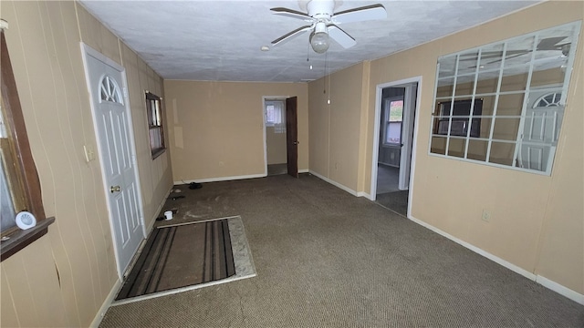 spare room with ceiling fan and dark carpet