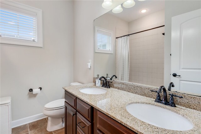 bathroom with tile patterned floors, vanity, toilet, and curtained shower