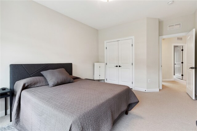 bedroom featuring light carpet and a closet