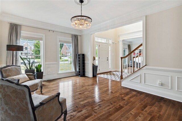 entrance foyer featuring hardwood / wood-style floors, a chandelier, and ornamental molding