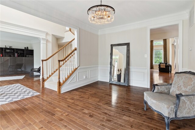 foyer with a notable chandelier, crown molding, and dark wood-type flooring