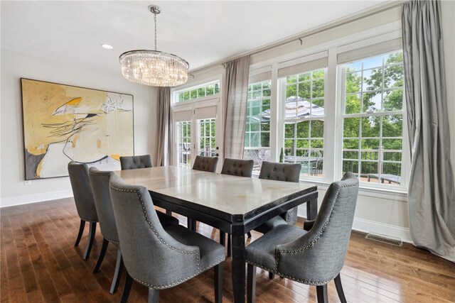 dining space with wood-type flooring and an inviting chandelier