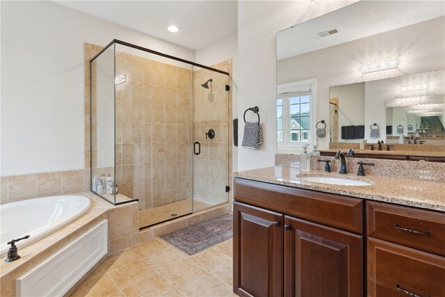 bathroom featuring tile patterned flooring, shower with separate bathtub, and vanity