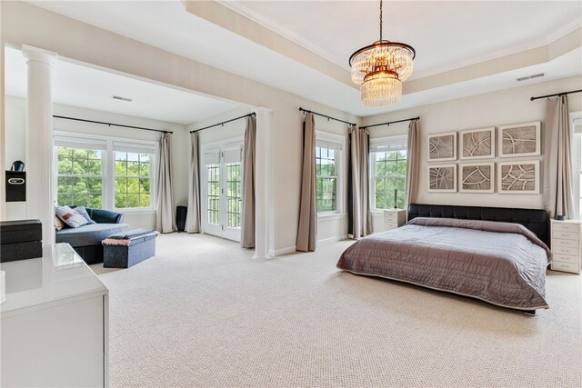 bedroom featuring carpet, a notable chandelier, a tray ceiling, and multiple windows