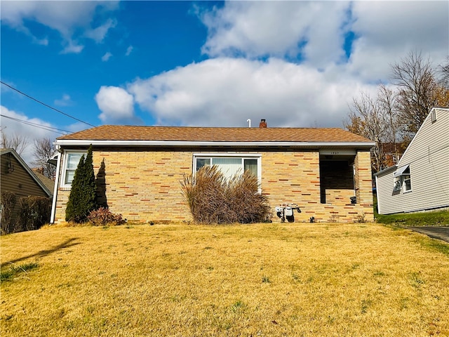 rear view of house featuring a lawn