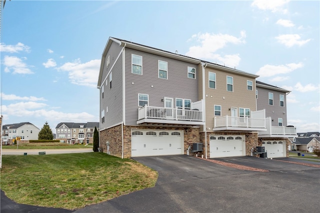 back of property with a lawn, a garage, and central AC