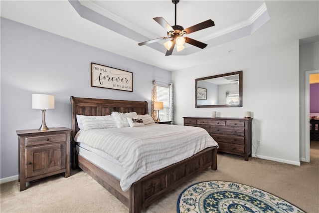 carpeted bedroom featuring a raised ceiling, ceiling fan, and crown molding