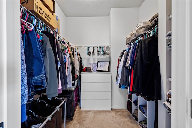 walk in closet featuring light colored carpet