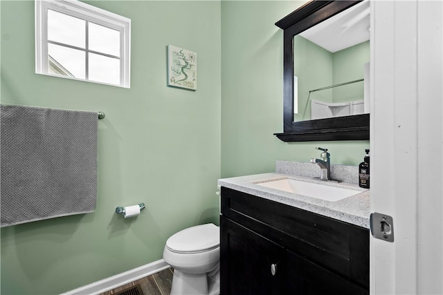 bathroom featuring vanity, toilet, and wood-type flooring