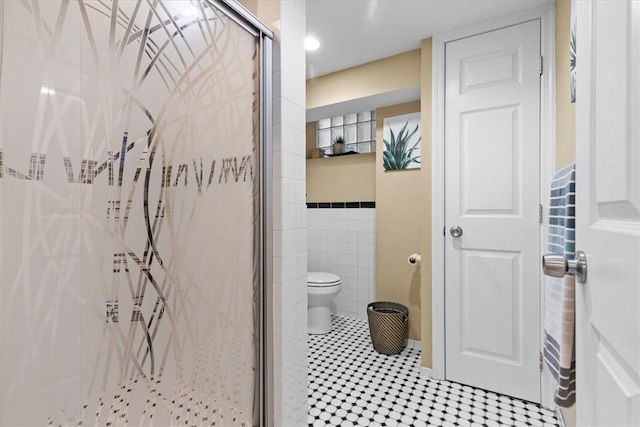 bathroom featuring toilet, tile walls, and walk in shower