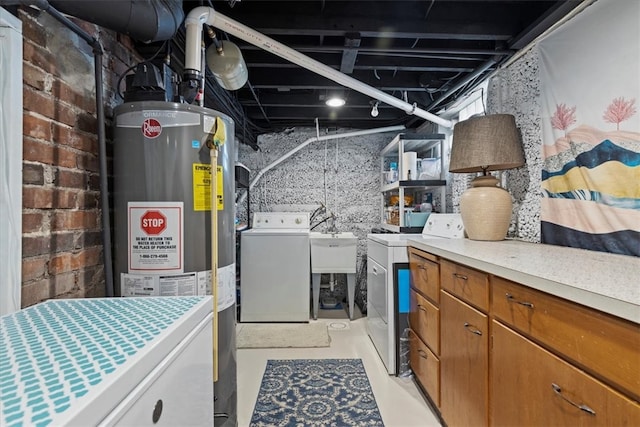 laundry room with separate washer and dryer, gas water heater, and sink