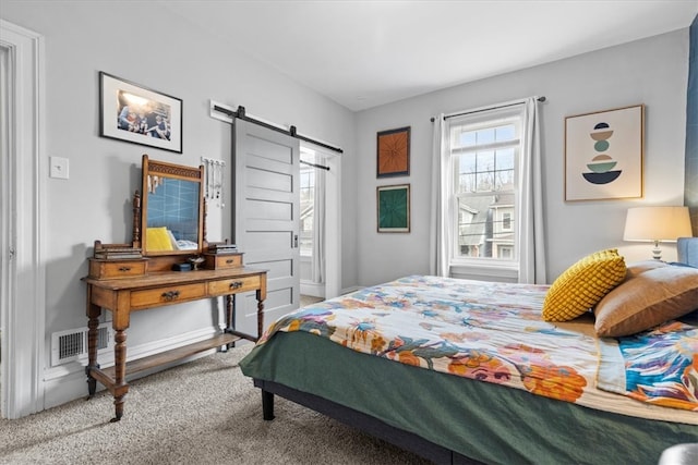 carpeted bedroom featuring a barn door