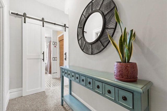 corridor featuring light carpet and a barn door