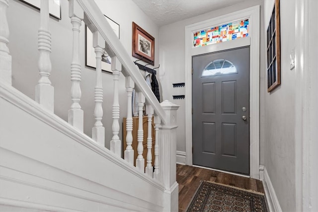 entryway with dark hardwood / wood-style floors and a textured ceiling