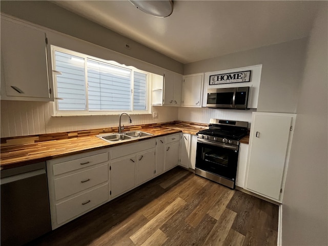 kitchen featuring white cabinets, butcher block counters, sink, and appliances with stainless steel finishes