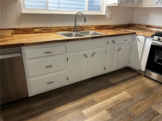 kitchen with white cabinets, sink, light hardwood / wood-style flooring, appliances with stainless steel finishes, and butcher block counters