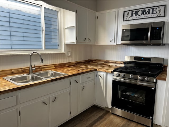 kitchen featuring butcher block countertops, white cabinetry, and appliances with stainless steel finishes