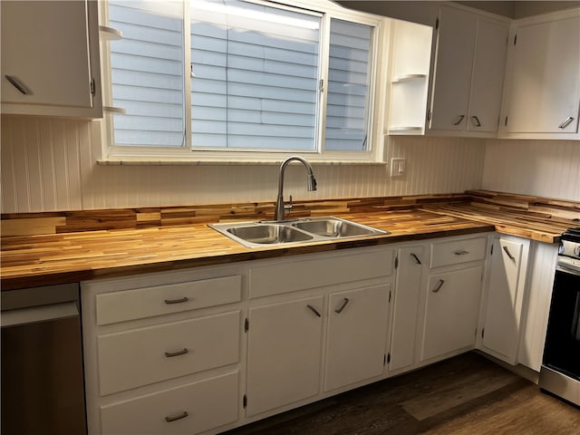 kitchen featuring dark wood-type flooring, sink, stainless steel range oven, white cabinets, and butcher block countertops