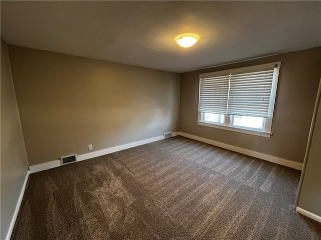 spare room with dark carpet