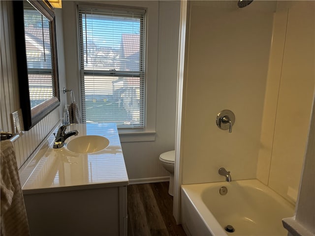 full bathroom featuring hardwood / wood-style flooring, vanity, toilet, and bathtub / shower combination