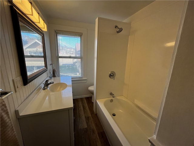 full bathroom featuring hardwood / wood-style floors, vanity, toilet, and bathtub / shower combination