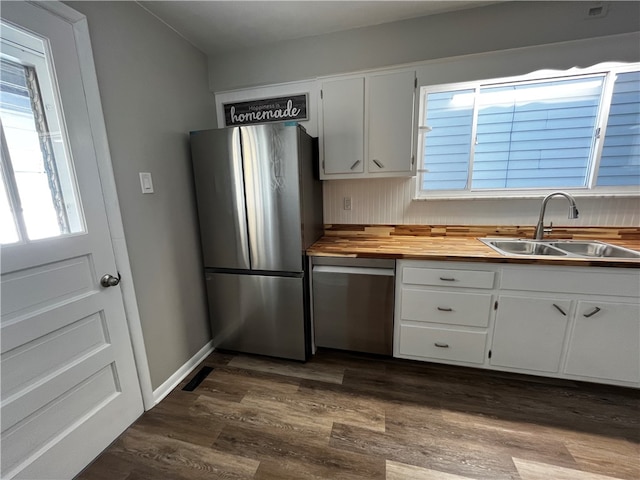 kitchen featuring white cabinets, sink, appliances with stainless steel finishes, butcher block countertops, and dark hardwood / wood-style flooring