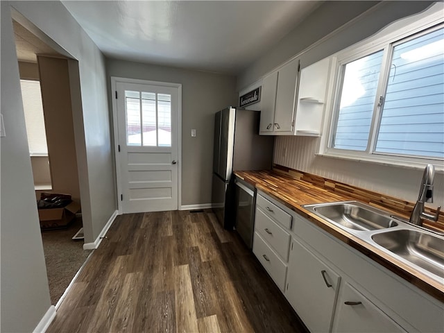 kitchen with wood counters, sink, dark hardwood / wood-style floors, white cabinetry, and stainless steel appliances