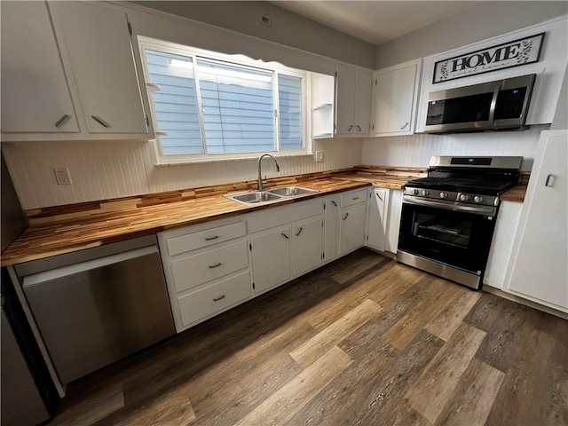 kitchen with white cabinets, appliances with stainless steel finishes, and wooden counters