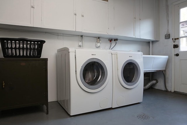 washroom featuring cabinets and washing machine and dryer