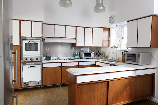 kitchen with white gas cooktop, a high ceiling, white cabinets, sink, and kitchen peninsula