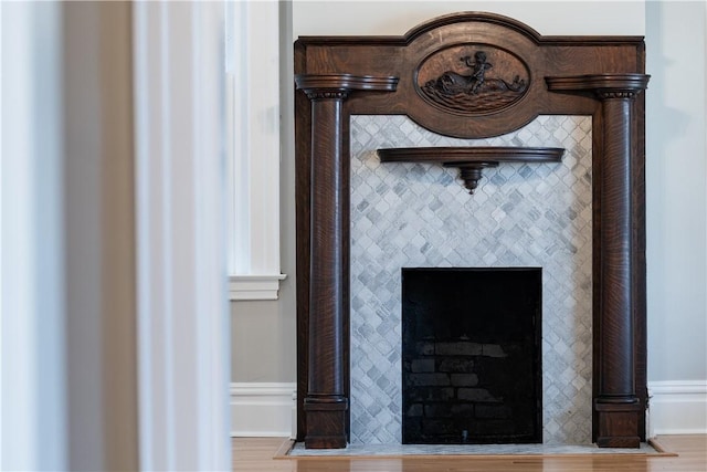 details featuring wood-type flooring and a tiled fireplace