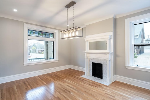 unfurnished living room featuring hardwood / wood-style flooring, a healthy amount of sunlight, and a premium fireplace