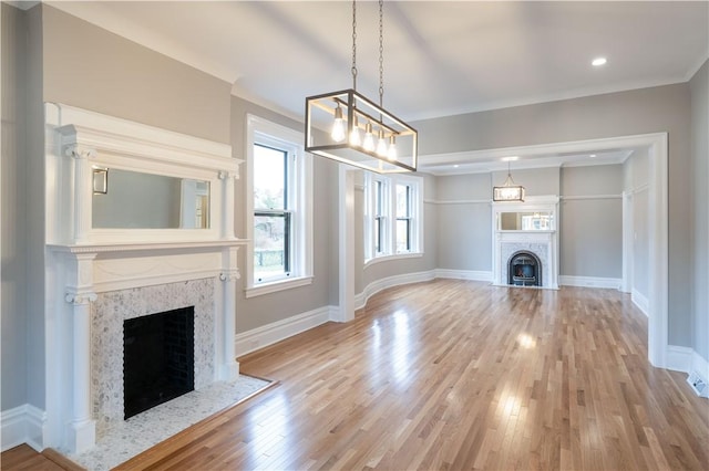 unfurnished living room featuring light wood-type flooring and ornamental molding