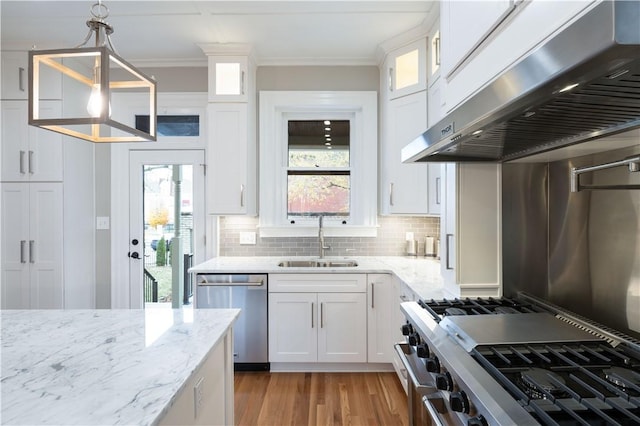 kitchen with pendant lighting, white cabinets, sink, stainless steel appliances, and extractor fan