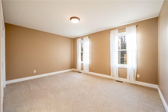 unfurnished room featuring carpet flooring and a textured ceiling