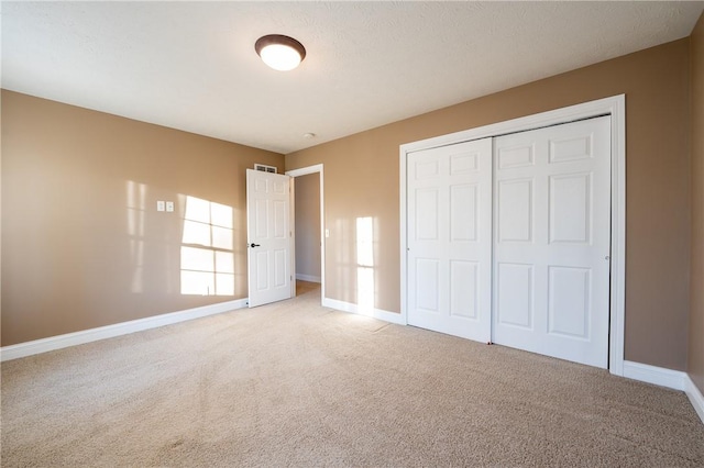 unfurnished bedroom featuring carpet flooring and a closet