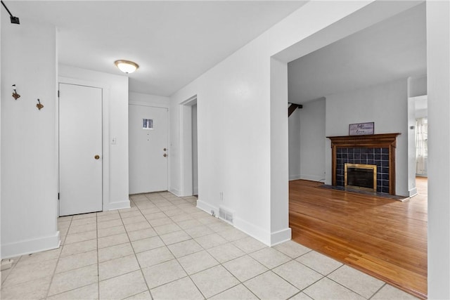 interior space featuring a tile fireplace and light wood-type flooring