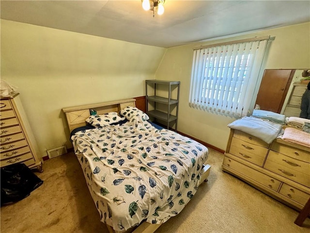 bedroom featuring lofted ceiling and light carpet