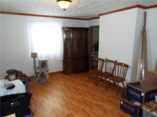 sitting room with hardwood / wood-style floors and crown molding