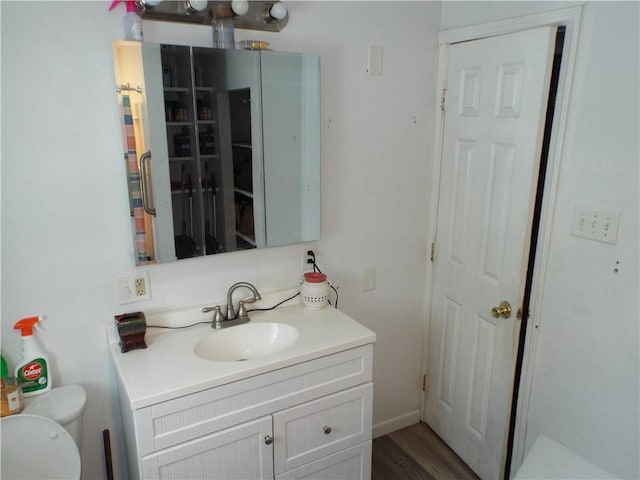 bathroom with hardwood / wood-style flooring, vanity, and toilet