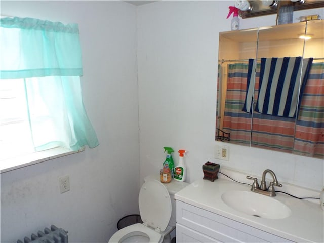 bathroom featuring vanity, toilet, and radiator heating unit