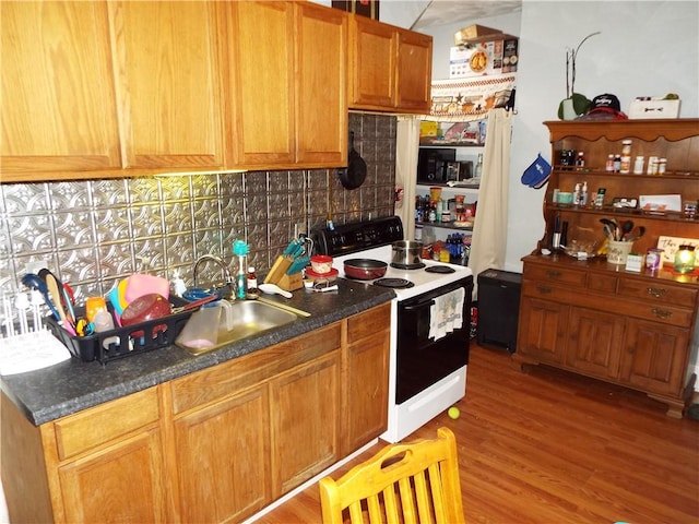 409 1st St, East Bethlehem, PA 15368 - kitchen with electric range oven, tasteful backsplash, light wood finished floors, a sink, and dark countertops