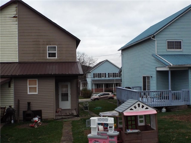 409 1st St, East Bethlehem, PA 15368 - back of property featuring metal roof, a lawn, and a wooden deck