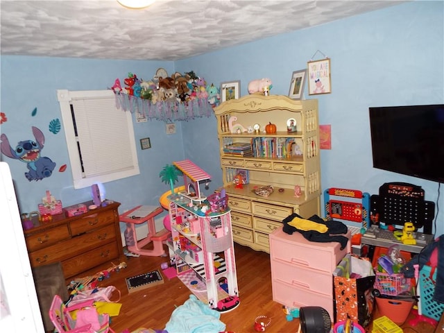 playroom featuring hardwood / wood-style floors and a textured ceiling