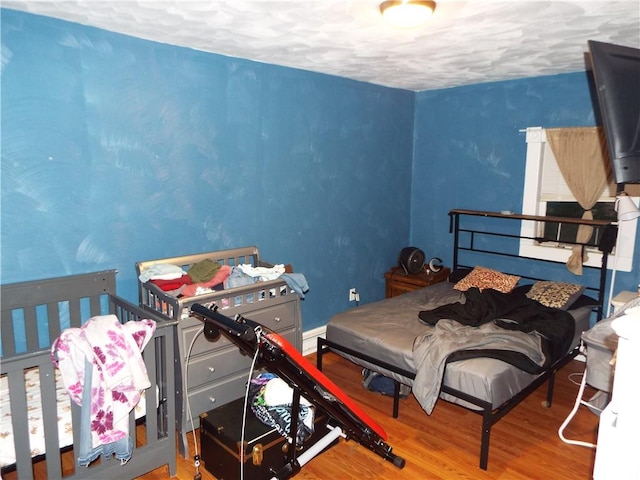 409 1st St, East Bethlehem, PA 15368 - bedroom featuring wood finished floors, a textured ceiling, and a baseboard heating unit