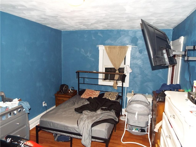 bedroom with dark wood-type flooring