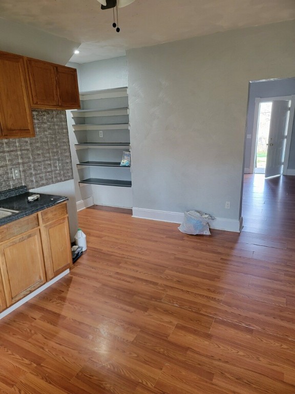 409 1st St, East Bethlehem, PA 15368 - kitchen with light wood-type flooring, dark countertops, baseboards, backsplash, and ceiling fan