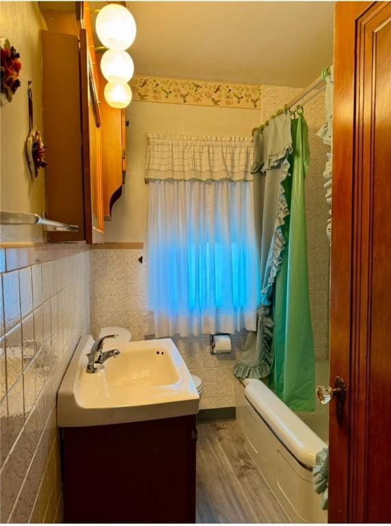 bathroom featuring shower / tub combo with curtain, vanity, tile walls, and hardwood / wood-style flooring